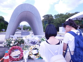 原爆死没者慰霊碑（広島平和都市記念碑）に手を合わせる折り鶴平和大使