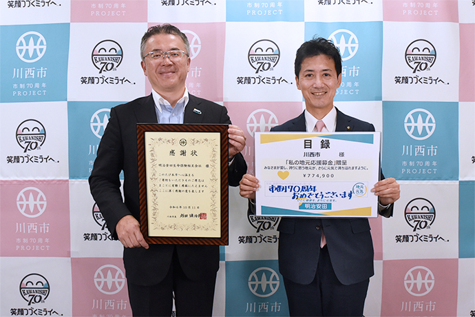 感謝状を持つ明治安田生命の代表者と市長