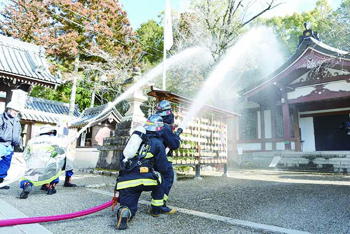 建物に放水する消防隊員